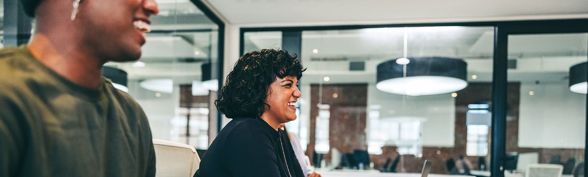 Office staff laughing during meeting