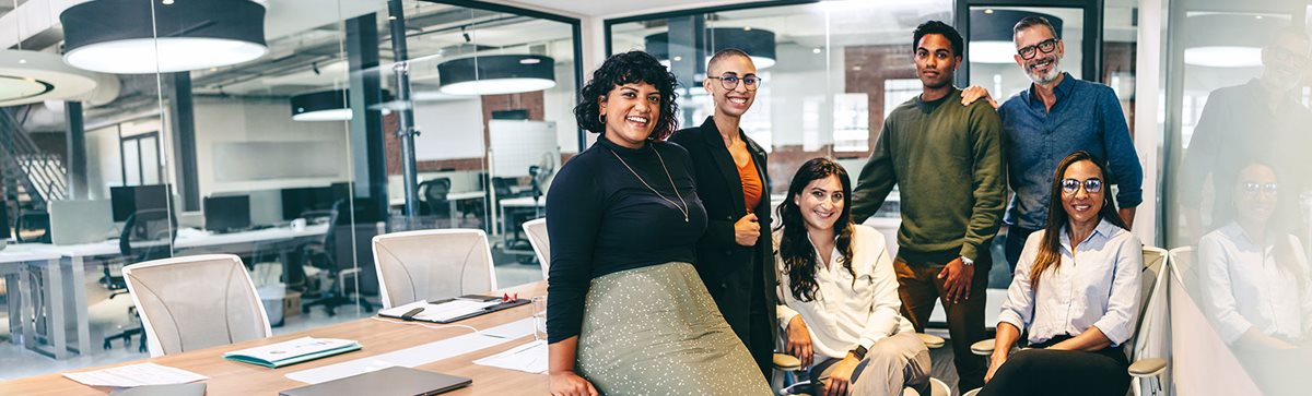 Office staff posing for photo in boardroom