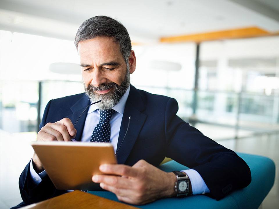 Man thoughtfully looking at a tablet computer